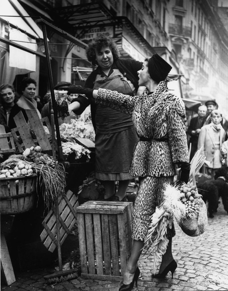 Marie Chantal en manteau d'Ocelot de Balmain, au march de la rue Mouffetard . Elle choisi ses lgumes en accord avec son panier. Publi dans Life 1955 © Pierre Boulat / Cosmos